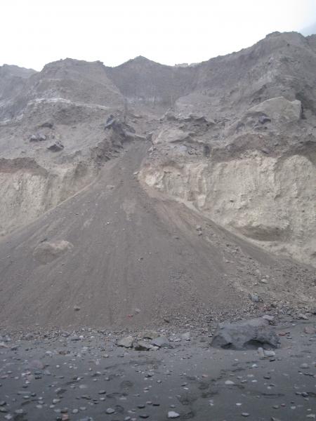 2008 deposits exposed on north beach include thin fallout deposits and thick pyroclastic-flow deposits. Fallout deposits are exposed near white bands crossing outcrop near top of colluvial cone. Coarse pumice clasts come from pyroclastic-flow deposit underlying lapilli fall beds.