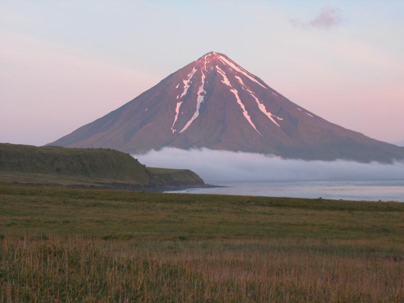 Taken from Applegate Cove on Chuginadak Island in July of 2002; this image shows the southeast flank and summit of Mt. Carlisle volcano. A lava flow from Mt. Cleveland volcano is in the middle left of the image. 