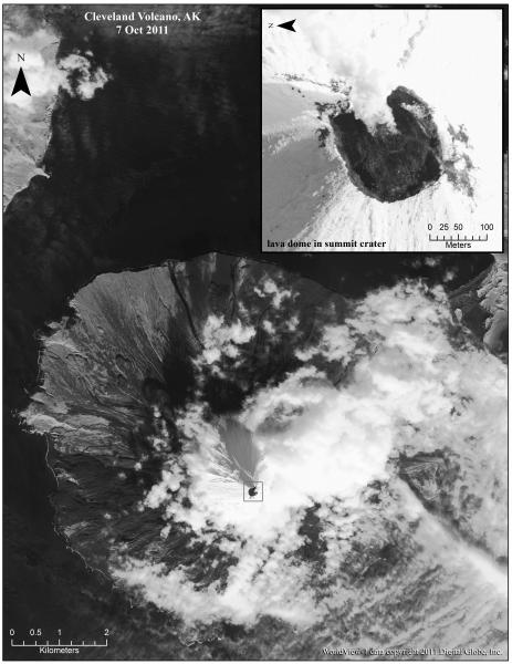 Panchromatic satellite image of Cleveland Volcano collected by the Worldview-1 sensor on 7 October 2011. The summit of the volcano is mostly snow-covered, and the growing lava dome is seen as the dark feature in the center of the volcano (inset area outlined by black square). A faint steam and gas plume is observed moving towards the northeast (upper-right).  The inset is a rotated close-up view showing the lava dome filling much of the summit crater.  The inset also shows some snow-free areas just outside of the summit crater.  