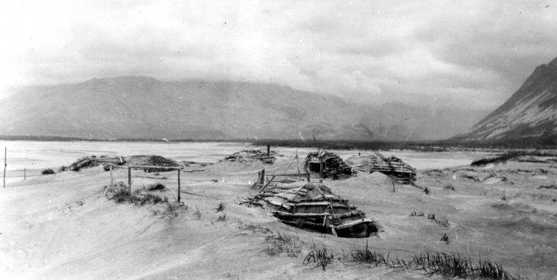 Photograph of ash drifts around Katmai village barabaras (sod houses) after the June 1912 eruption of Novarupta. Photo taken by G.C. Martin, U.S. Geological Survey. This image is image mgc00745 in the U.S.G.S. photolibrary.