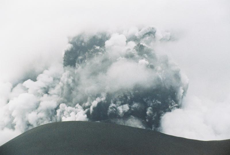 Okmok Volcano in eruption.  Ash and steam billow from the new tephra cone formed during the 2008 eruption. Photograph courtesy of Bill Springer.