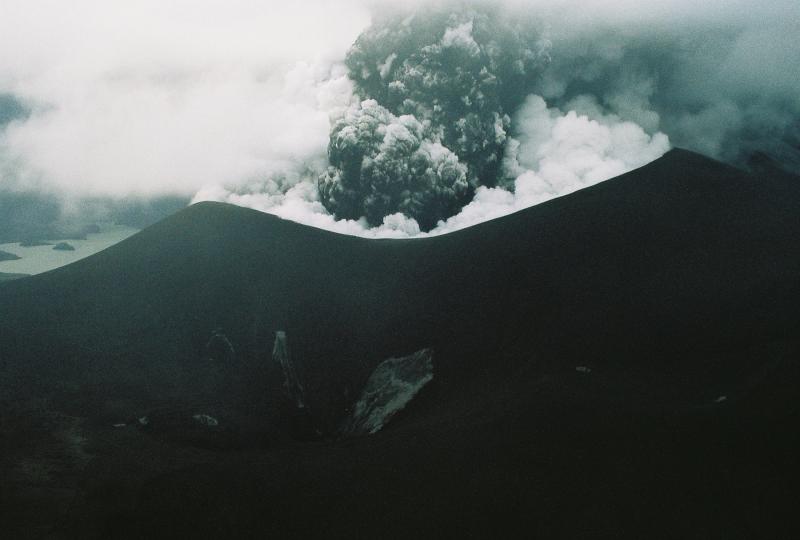 Okmok Volcano in eruption.  Ash and steam billow from the new tephra cone formed during the 2008 eruption.