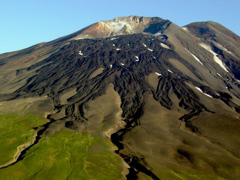 Gareloi Volcano, elevation 1573 m, in the western Aleutian Islands, Alaska.  Levied lava flows from a 1980s eruption drape the south flank of the southern summit crater.  The white zone on the crater headwall is an extensive fumarole field.