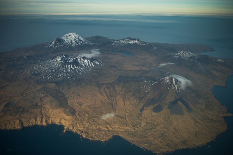 Semisopochnoi volcano, November 2012. Oblique aerial photograph courtesy of Roger Clifford. Semisopochnoi consists of a large caldera (about 8 km or 5 miles across) and a number of significant post-caldera composite cones.  In this photo, the three closely-spaced snow dappled cones in the middle form the Cerberus complex.  The large cone at lower right is called Sugarloaf.