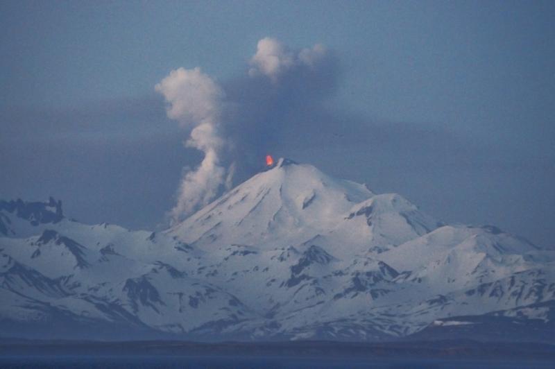 Pavlof Volcano in eruption.  View is from the southwest in Cold Bay.  Lava fountaining is visible near the summit, and steam and ash clouds rise from the northwest flank where a lava flow advances down the slope.