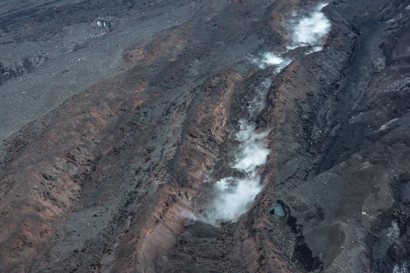 Lava flows on the northwest flank of Pavlof Volcano. Steaming area is the result of water flow along the axis of the lava flow. View is toward the southeast.