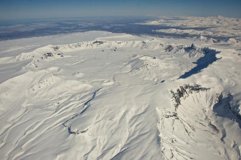 Aerial view of snow-covered, 6-mile-wide, Aniakchak Caldera on the Alaska Peninsula. View is towards the north-northeast. Aniakchak last erupted in 1931. Chiginagak Volcano is the high peak on the far right horizon. Photo courtesy of Roy Wood, NPS, March 10, 2013.