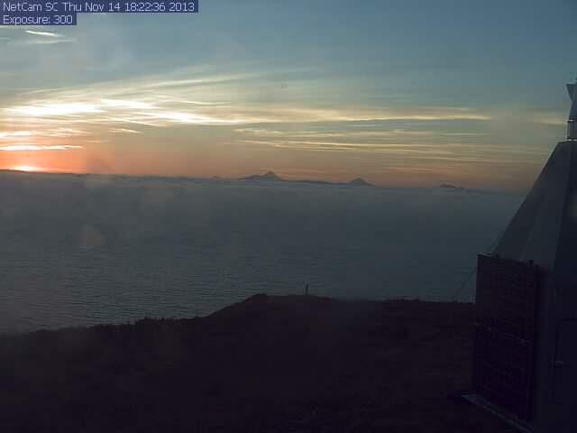 Sunset image taken by the AVO web camera looking at Cleveland Volcano. This camera is located on top of High Hill a few miles North of the village of Nikolski on the western end of Umnak Island. Mount Cleveland is approximately 45 miles from the camera; it is the peak at the center of the image. Mount Carlisle, another young volcano, is to the right.