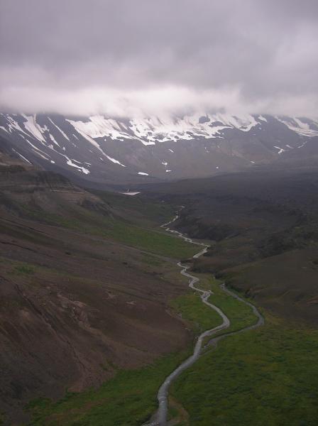 View south along eastern caldera wall of Aniakchak of the drainage that connects the maar crater lake (in distance) to the Aniakchak River at The Gates.  This drainage was significantly affected by a break-out flood of the maar lake in late summer 2011.  Compare with image 57551.