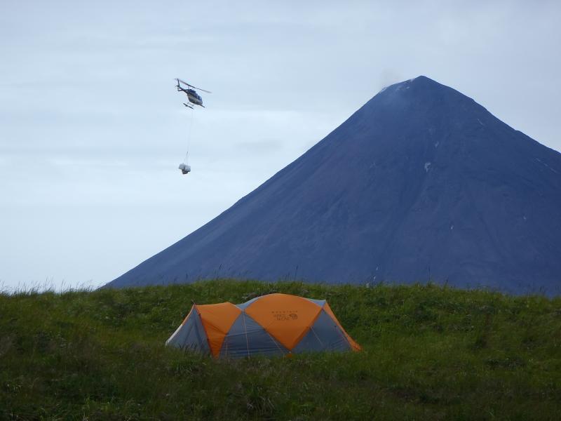 Slinging gear to set up camp on Carlisle. Cleveland in the background. Photo taken during the 2014 field season of the Islands of Four Mountains multidisciplinary project, work funded by the National Science Foundation, the USGS/AVO, and the Keck Geology Consortium.