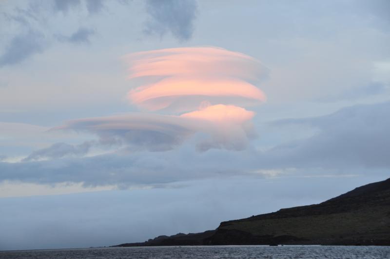 Lenticular cloud formations looking west over the southern coast of Cleveland volcano from the deck of the Maritime Maid, anchored in South Cove.  Photo taken during the 2014 field season of the Islands of Four Mountains multidisciplinary project, work funded by the National Science Foundation, the USGS/AVO, and the Keck Geology Consortium.