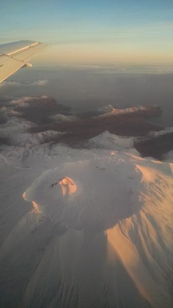 Akutan volcano&#039;s caldera and intracaldera cone, as seen from the air, looking to the southeast. The Alaska community of Akutan lies about 9 miles northeast, and is not visible in this photograph.