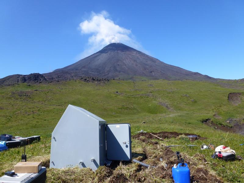 View of Cleveland Volcano from seismic station CLES in the process of installation. A typical steam and gas cloud rise above the summit crater. Photographs from fieldwork in the Islands of Four Mountains, July and August 2014.
