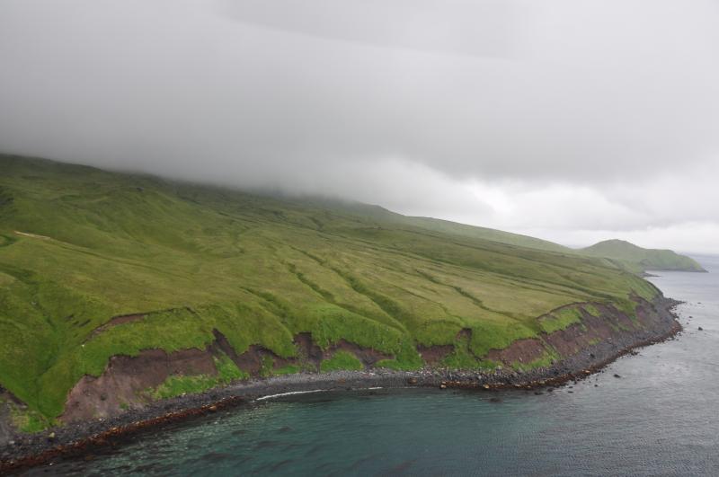 Counter clockwise orbit of Carlisle volcano just offshore in strong wind. Eastern coastline, water of Carlisle Pass in foreground. Photo taken during the 2014 field season of the Islands of Four Mountains multidisciplinary project, work funded by the National Science Foundation, the USGS/AVO, and the Keck Geology Consortium.