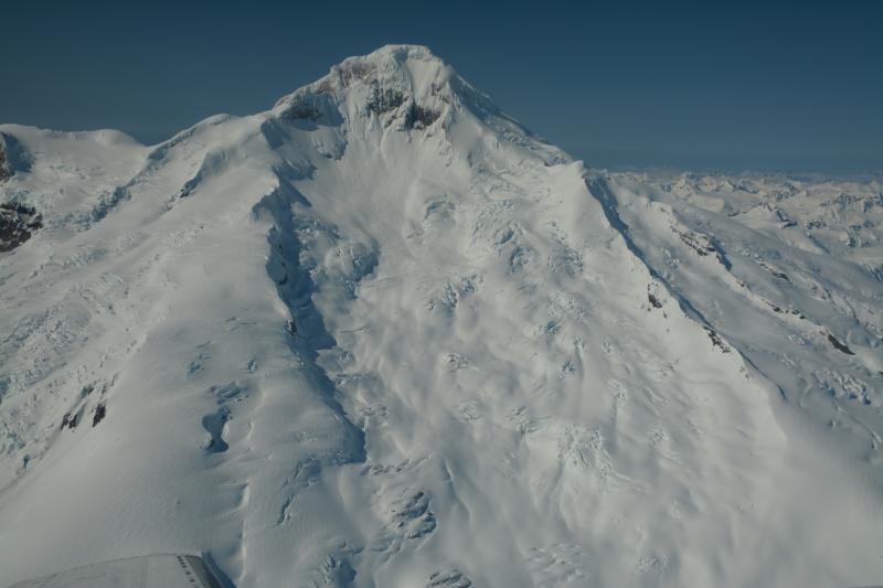 Aerial view of the east flank of Iliamna Volcano.  The Red Glacier is directly below the exposed rock near the summit, and flows down the east flank.   Rock/snow/ice avalanches often cascade down upon the glacier.