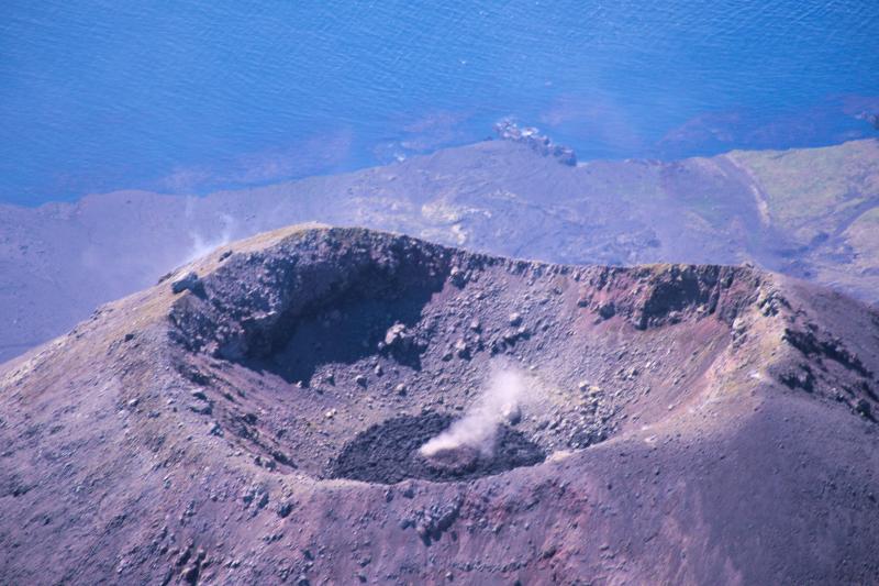 Cleveland Volcano overflight, August 4, 2015. Minor degassing observed at center of lava dome. Photo taken during the 2015 field season of the Islands of Four Mountains multidisciplinary project, work funded by the National Science Foundation, the USGS/AVO, and the Keck Geology Consortium.