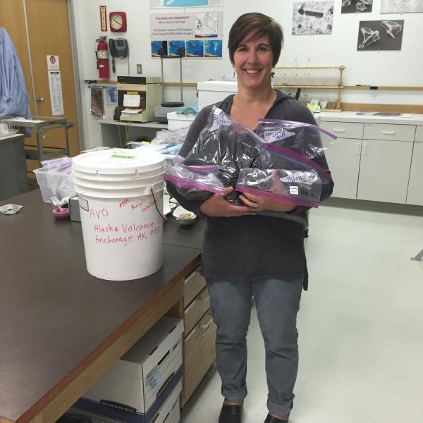 AVO Staff Kristi Wallace holding the 8.5 kg of Pavlof ash collected in Nelson Lagoon after the March 28, 2016 fallout.  Samples courtesy of Allan Brendall of Nelson Lagoon.