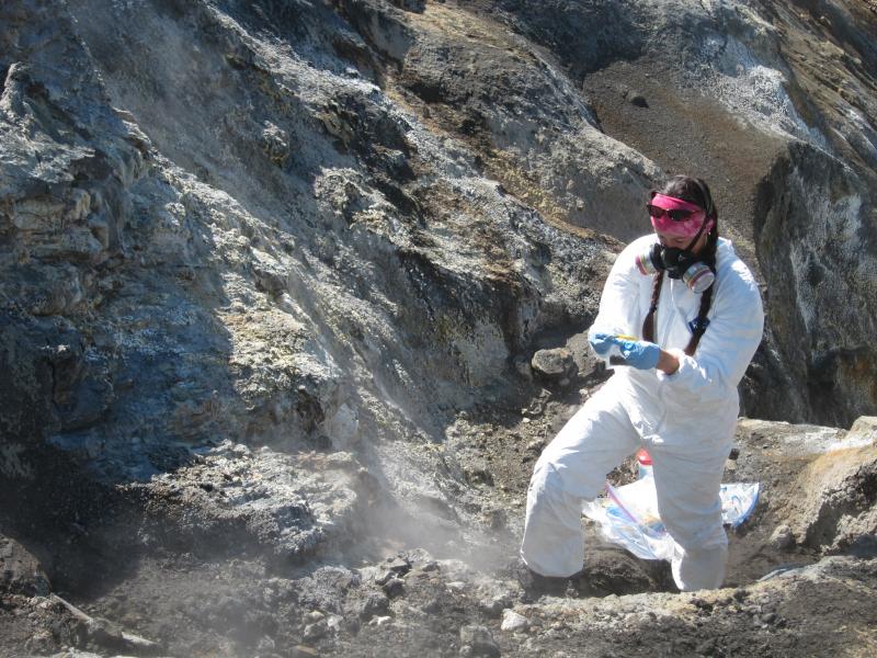 Taryn Lopez collects a soil sample from the upper part of a drainage in a fumarole field on Okmok Volcano.