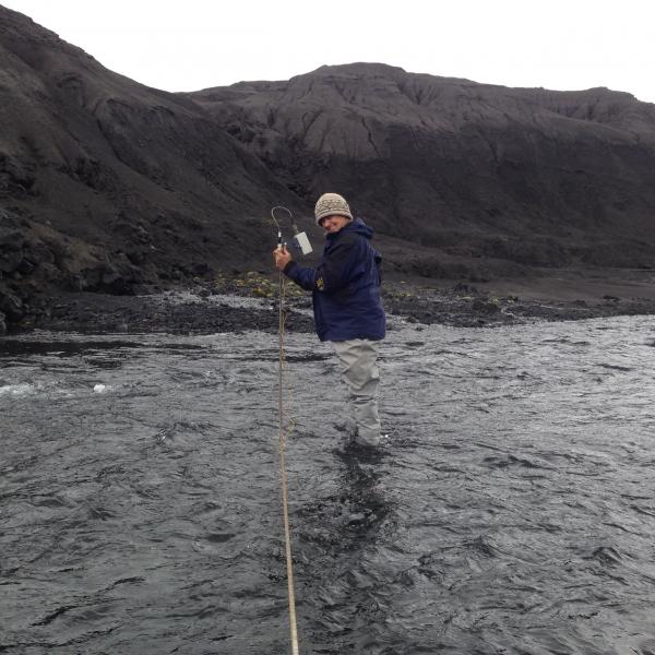 Deb Bergfeld (USGS) collects water discharge measurements within Okmok&#039;s caldera.