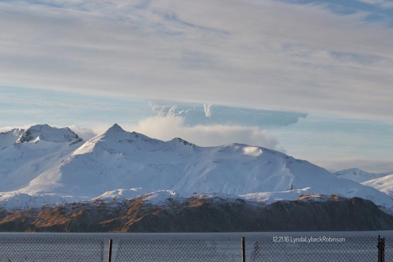 A plume rises from Bogoslof volcano, partially obscured by a mountain on Unalaska Island, in this view from Unalaska, about 60 miles east of the volcano, on Wednesday, Dec. 21, 2016. (Lynda Lybeck-Robinson / ADN reader submission)
