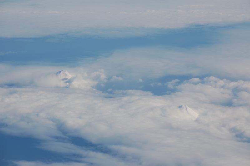 Cleveland Volcano with ground hugging steam plume (left) and Carlisle Volcano (lower right)  of the Islands of Four Mountains group,  Aleutian Islands.  This image was taken from a passing Alaska Airlines jet two days after an explosive event at the summit of Cleveland Volcano.