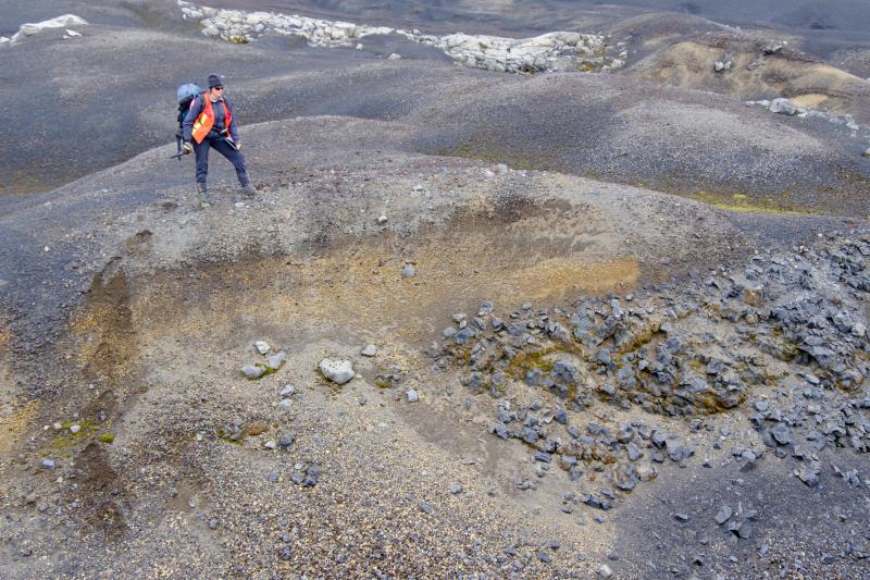 Janet Schaefer (DGGS/AVO) standing on a high elevation outcrop of Fisher caldera airfall that is deposited above a Pleistocene lava flow on the southeast flank of Shishaldin.