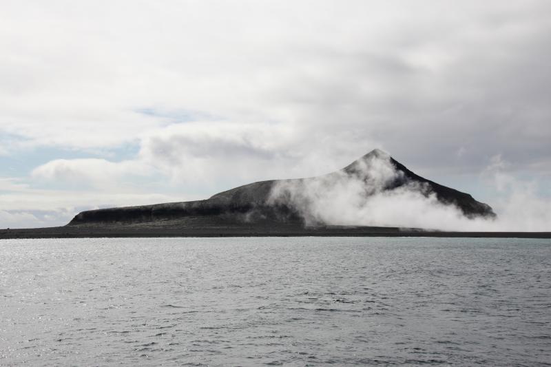 Day 1 of Bogoslof field work in August 2018. View from ship facing east showing steaming 2016-17 dome, fumaroles, and southern shelf.