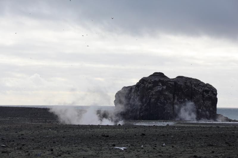 Day 1 of Bogoslof field work in August 2018. 1926-27 dome with steam from west lake fumaroles (left) and near-boiling lake (right). View from north northern shelf.