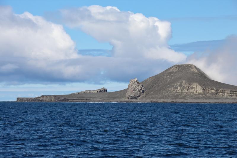 Day 2 of Bogoslof field work. View of Bogoslof Island, taken from ship facing north. Left to right: western beach cliffs, top of 1926-27 dome, Castle Rock, back of steaming 2016-17 dome, and part of southern shelf.