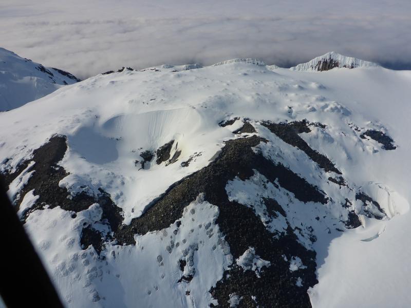 View of the summit dome at Great Sitkin during a gas flight. Very weak diffuse degassing observed all around the margins of the dome and also within the small crater on top. View is roughly to the north.