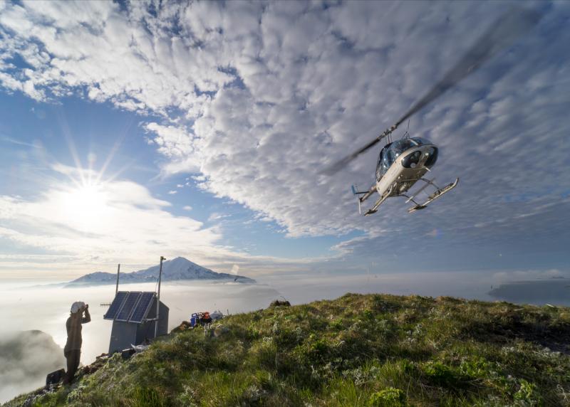 Helicopter landing at Alaska Volcano Observatory Great Sitkin volcano monitoring station GSIG.