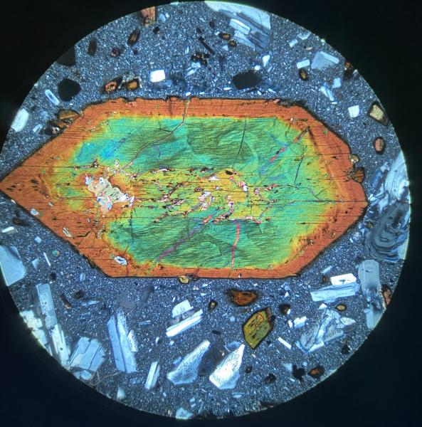 Large amphibole crystal viewed in cross-polarized light from a sample of lava domes at the summit of Adagdak volcano. Image is about 4 mm across. Photo taken by Matt Loewen, USGS/AVO, February 25, 2020.