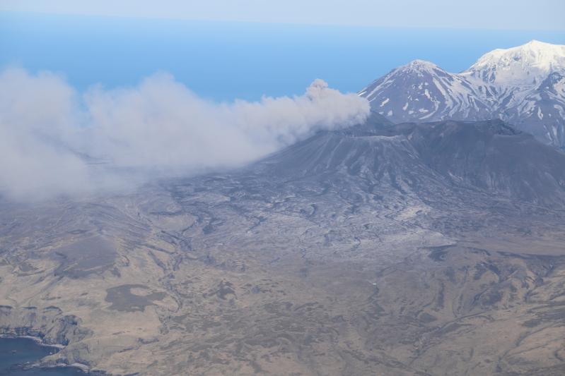 The ash plume from the eruption from the North Crater of Mount Cerberus at Semisopochnoi on May 30, 2021 as viewed from the SE in a helicopter. Ash deposits are visible on the southeastern flanks of Mount Cerberus.