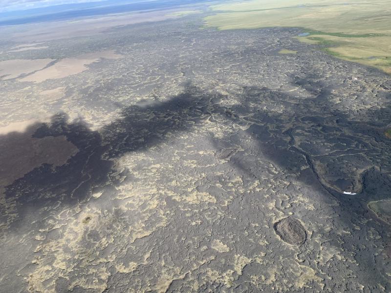 View of the Lost Jim (gray) and Camille (brown) lava flows, the two youngest lava flows in the Imuruk Lake Volcanic Field. Shatter rings, near center and at lower right, mark the trace of lava tube hidden beneath the flow surface.