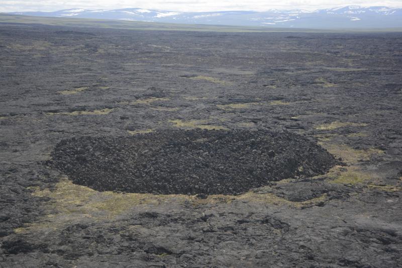 Close aerial view of a shatter ring on the Lost Jim lava flow. Shatter rings form over active lava tubes due to fluctuations in discharge, which causes the lava tube roof to flex repeatedly up and down.