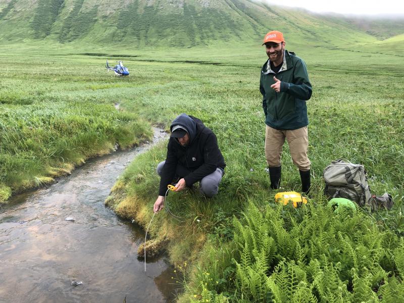Allan Lerner (USGS-CVO) and Mike Grover (Pathfinder Aviation) check temperatures at False Pass hot springs, east of False Pass, in June 2021.
