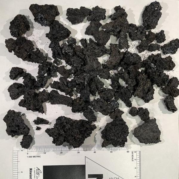 A representative sample of larger scoriaceous lapilli collected from Shishaldin Volcano at monitoring site ISNN on August 21, 2023, during the 2023 eruption of the volcano. The grain size card in the photo shows the size of the lapilli.