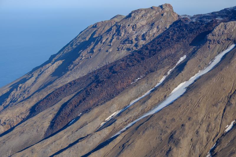 Oblique view of Great Sitkin Volcano looking north at lava flows from the crater taken on September 1, 2023 during a helicopter overflight by AVO geologists. 