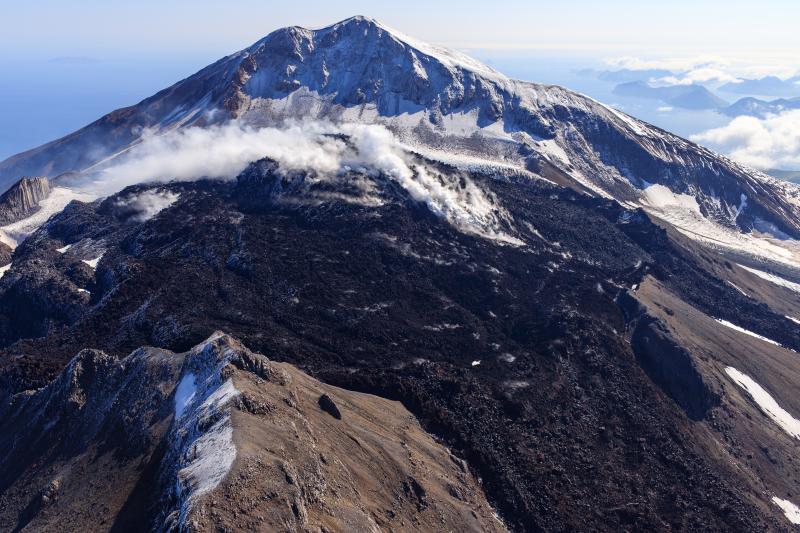 Oblique view of Great Sitkin Volcano looking east at the active lava flows in the crater with the Great Sitkin summit in the background. Photo taken on September 1, 2023 during a helicopter overflight by AVO geologists.