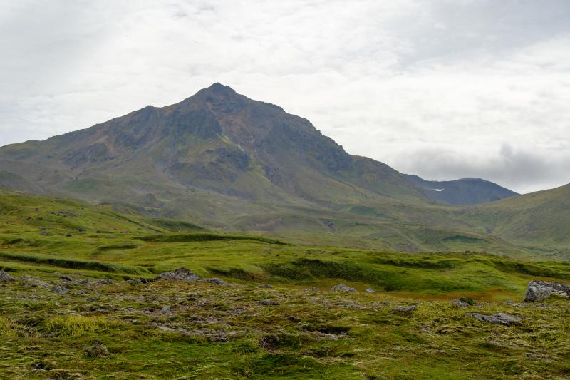 Eroded north face of the summit of Mount Moffett viewed from a glacial valley near the north coast of Adak Island.