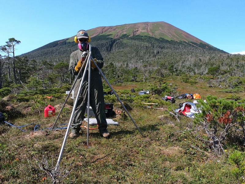 Installation of AVO&#039;s new seismic and GNSS network at Mt. Edgecumbe volcano, August 20-29 2023.   AVO field technician Max Kaufman constructs GNSS antenna monument at site EDES on the east flank of the mountain. 12 ft long by 1&quot; stainless steel rods are driven 7 ft into the muskeg, then trimmed and welded together at the top.