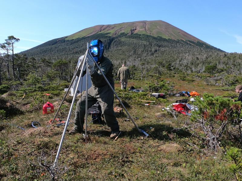 Installation of AVO&#039;s new seismic and GNSS network at Mt. Edgecumbe volcano, August 20-29 2023.   AVO field technician Max Kaufman constructs GNSS antenna monument at site EDES on the east flank of the mountain. 12 ft long by 1&quot; stainless steel rods are driven 7 ft into the muskeg, then trimmed and welded together at the top.