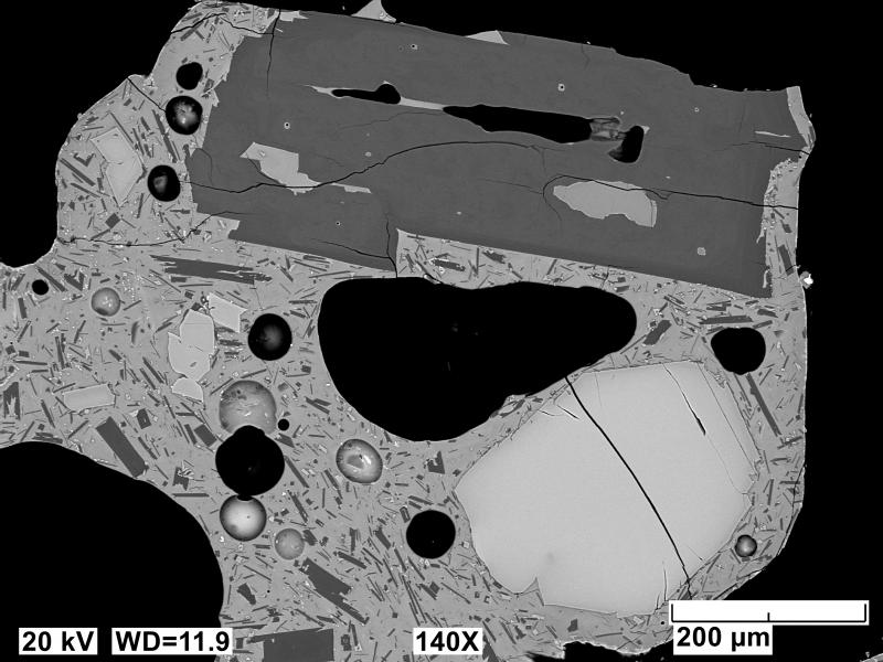 Backscatter electron images (BSE) of polished sections of tephra erupted from Shishaldin in 2023 and collected near AVO station ISNN northeast of the volcano. Sample has a vesicular, microlitic matrix with a normally zoned plagioclase (dark gray, top) and reversed zoned olivine (light gray, bottom right) phenocryst. 