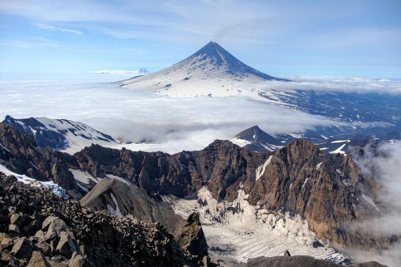 Northeast flank of Shishaldin Volcano viewed from high on the north flank of the neighboring Isanotski Peaks. A faint degassing plume is visible drifting north from the summit. Westdahl volcano is visible in the distance to the left of Shishaldin.