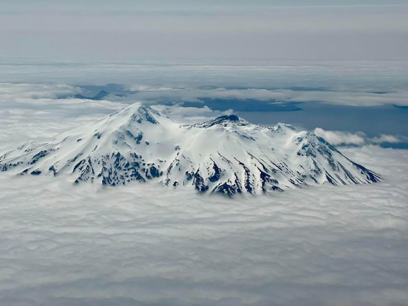 Aerial photo of Great Sitkin Volcano from the north. Some steam is visible on the on the active part of the lava dome, which is snow free.