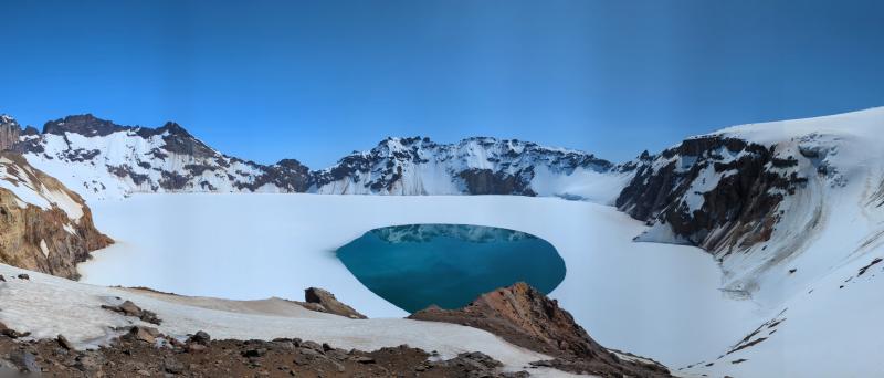 Katmai Caldera, viewed from the southeastern rim on June 15, 2024. The ice has melted directly above Horseshoe Island, a submerged eruptive vent formed after the caldera collapse in June 1912. Along with the observed water discoloration, this may indicate potential hydrothermal activity at Horseshoe Island.