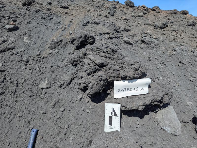 Volcanic bomb from the 2023 Shishaldin eruption, event #12 pyroclastic flow, with friable structure and vesicular core (24IPE12A).