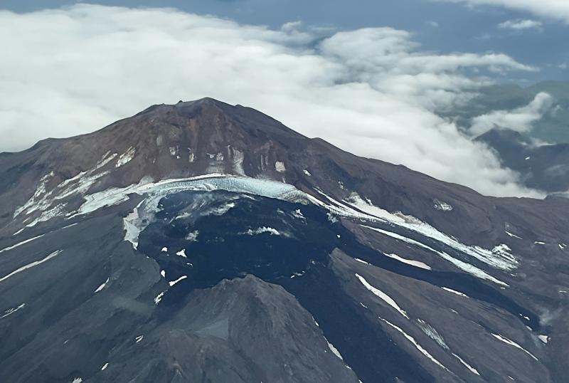 A close up view of the summit crater of Great Sitkin, taken from the air. The currently growing lava flow is steaming in places.
