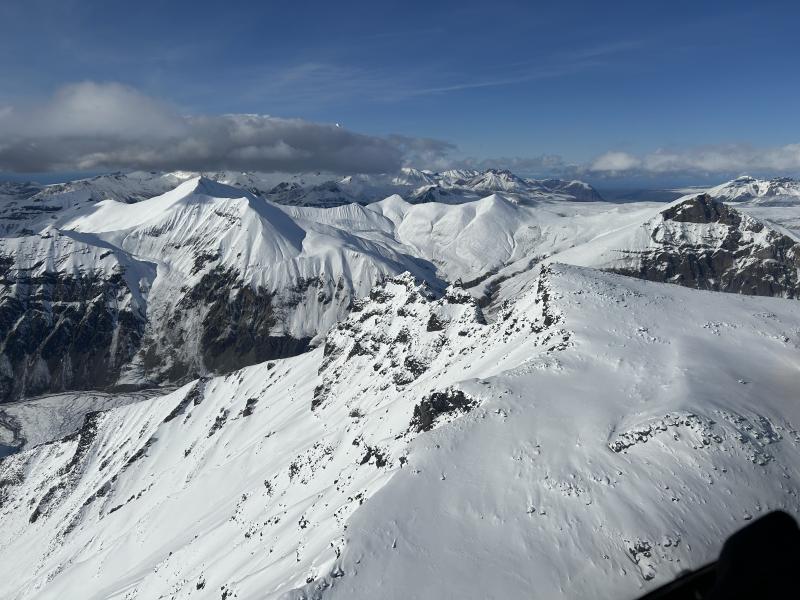 Looking northwest, seismic station WACK sits on a small outcrop halfway up the near ridge. Mount Drum at the top left is shrouded in clouds.