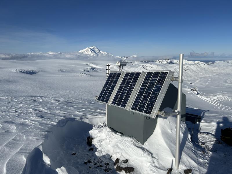 Mount Drum rises above the clouds behind seismic station WAZA. 